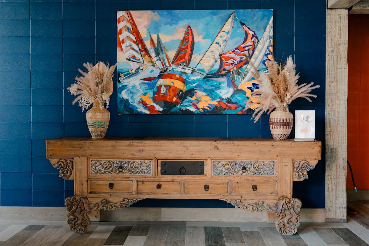 pexels-photo-32641364 Cozy rustic interior with vibrant sailboat painting and decorative elements, creating a nautical theme.